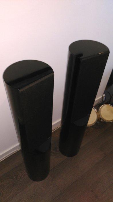 Conceptual installation of cylindrical heritage-style loudspeakers with modern architecture and a broad landscape view